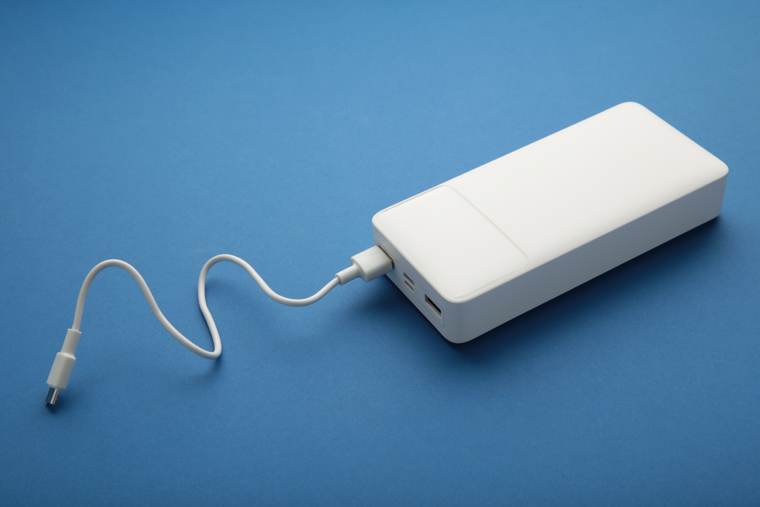 Portable powerbank with usb cable on blue background.